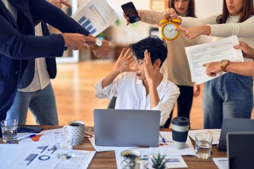 Office where groups of coworkers and bosses are harassing a worker. Visual concept for an employment law blog discussing hostile work environments.