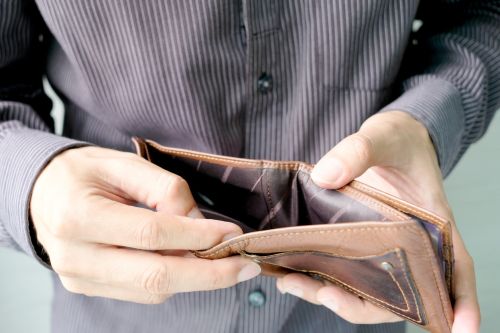 Man opening wallet to show there is no money inside. Visual concept for a blog by the employment law lawyers of Madsen, Prestley & Parenteau, LLC discussing Connecticut Minimum Wage Increase and Wage Theft Protection Laws.