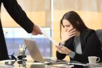 Worried woman in her office receiving a termination notification from her workplace. Visual concept for a Employment law attorney discussing wrongful termination in Connecticut.